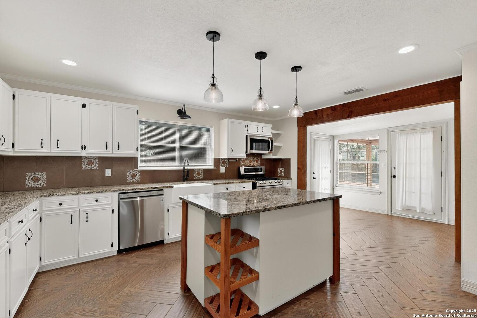 7140 Tree Bend Street China Grove, TX 78263 - Photo 17 of 49 a kitchen with stainless steel appliances granite countertop a sink a stove and a wooden floors