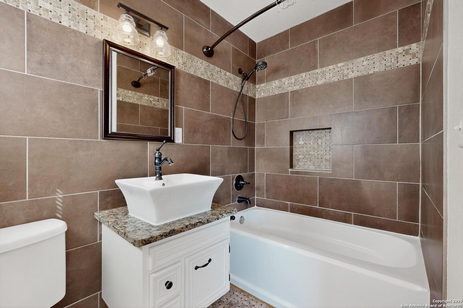 7140 Tree Bend Street China Grove, TX 78263 - Photo 24 of 49 a bathroom with a granite countertop sink a toilet and bathtub