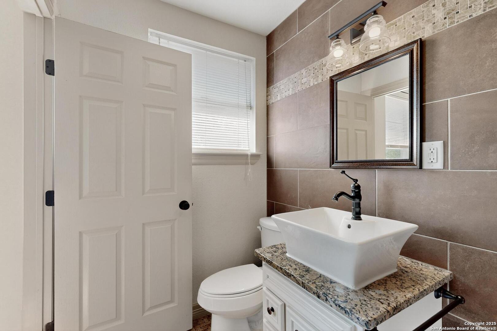 7140 Tree Bend Street China Grove, TX 78263 - Photo 25 of 49 a white toilet sitting next to a bathroom sink
