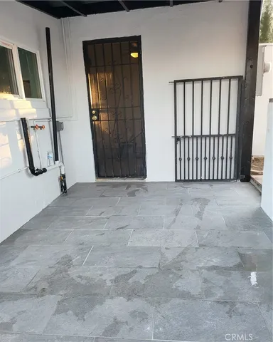 a view of an empty room with wooden floor and a sink