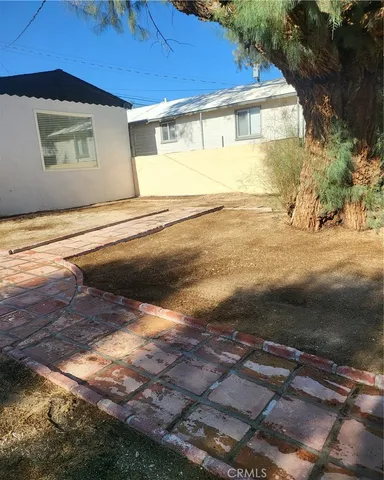 a view of a yard with plants and brick wall