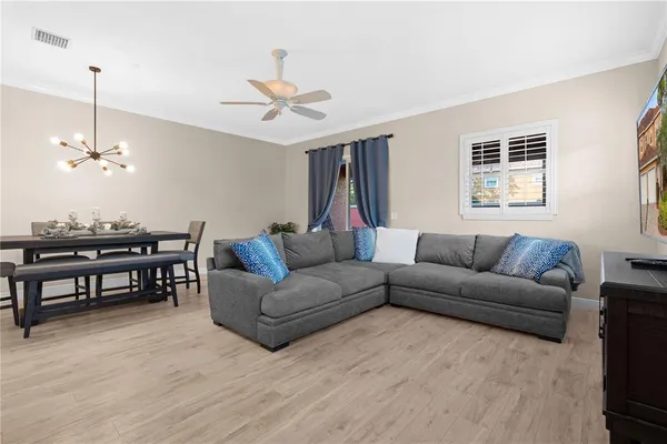a living room with furniture a ceiling fan and a window