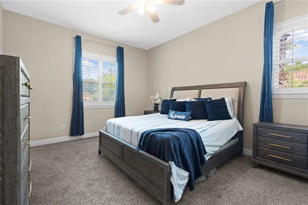 a bedroom with a bed lamp and a large window