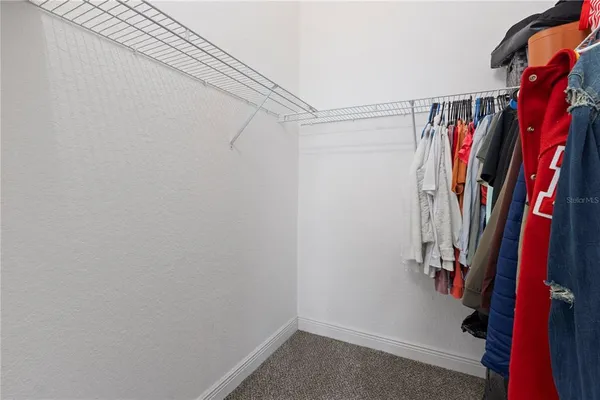 a view of walk in closet with clothes