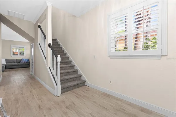 a view of a hallway with stairs and wooden floor