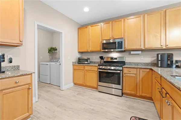 a kitchen with granite countertop a stove a sink and a microwave
