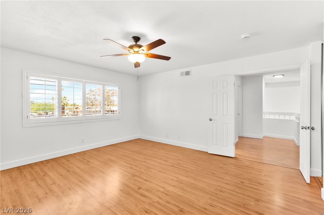 4430 Cranbrook Way Las Vegas, NV 89103 - Photo 34 of 50 A naturally illuminated bedroom offers inviting wood flooring and a refreshing ceiling fan.