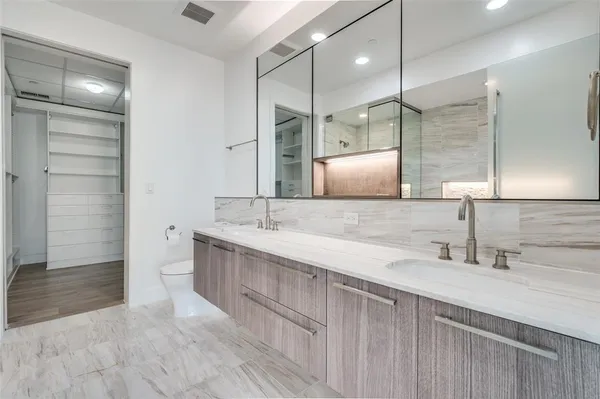 a bathroom with a double vanity sink a mirror and a shower