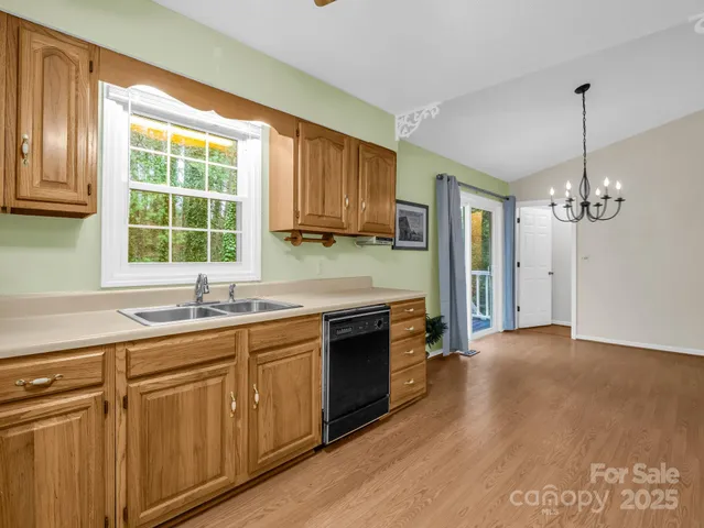 a kitchen with stainless steel appliances granite countertop a stove a sink and dishwasher with wooden floor