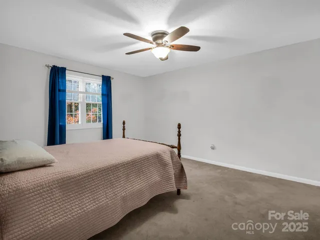 a bedroom with a large bed and a ceiling fan