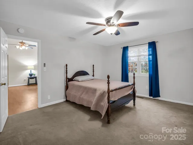 a spacious bedroom with a bed and a chandelier