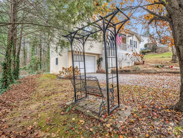 a view of a yard with plants and trees