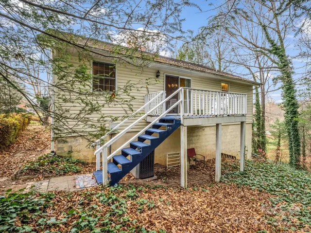 a view of a house with wooden fence and a stairs
