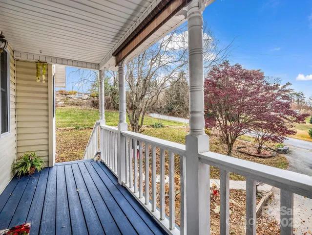 a view of a porch with wooden floor in front of house