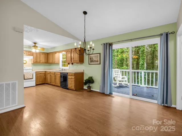 a view of a kitchen with refrigerator wooden floor and windows