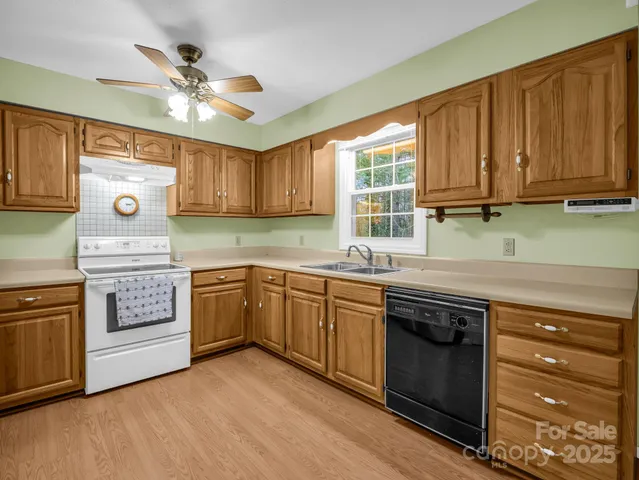 a kitchen with granite countertop a sink cabinets stainless steel appliances and a counter space