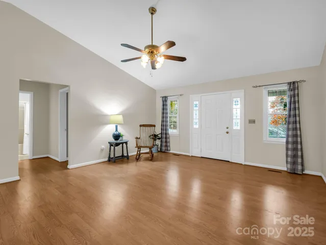 a view of a livingroom with a piano and wooden floor