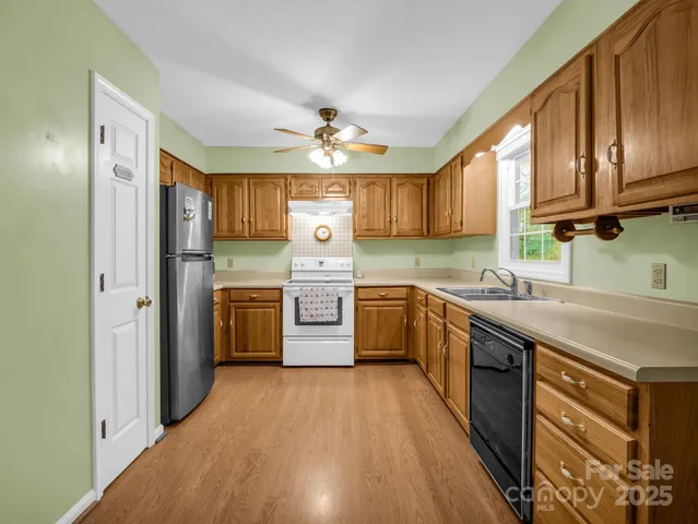 a kitchen with stainless steel appliances granite countertop a stove a sink dishwasher and a refrigerator