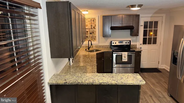 a kitchen with stainless steel appliances granite countertop a stove a sink and a refrigerator