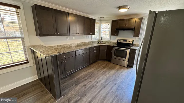 a kitchen with stainless steel appliances granite countertop a sink stove and microwave