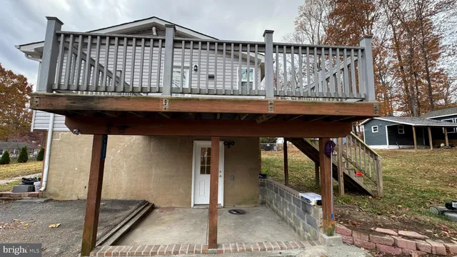 a view of a house with wooden deck front of house