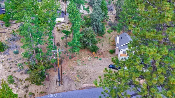 an aerial view of residential house with outdoor space and trees all around