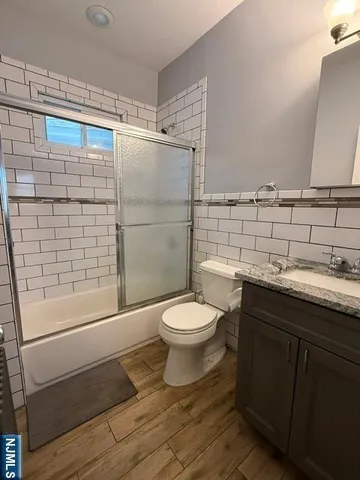a bathroom with a granite countertop toilet sink and shower