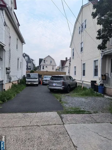 a view of car parked in front of white house