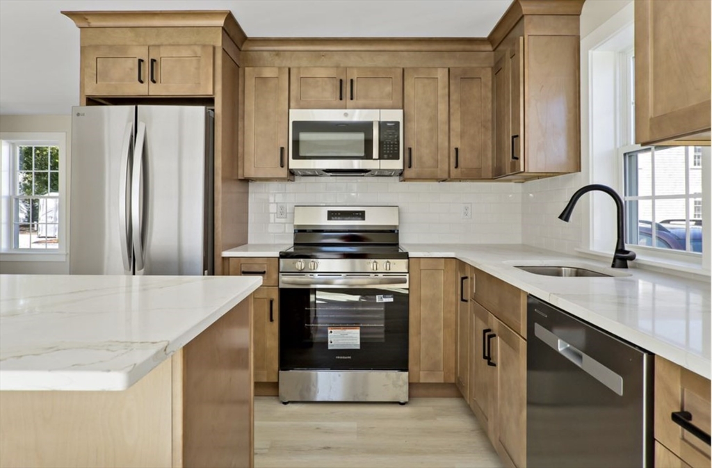 209 Main Street, Unit 1 Dennis, MA 02670 - Photo 11 of 28 a kitchen with stainless steel appliances granite countertop a stove top oven a sink and dishwasher