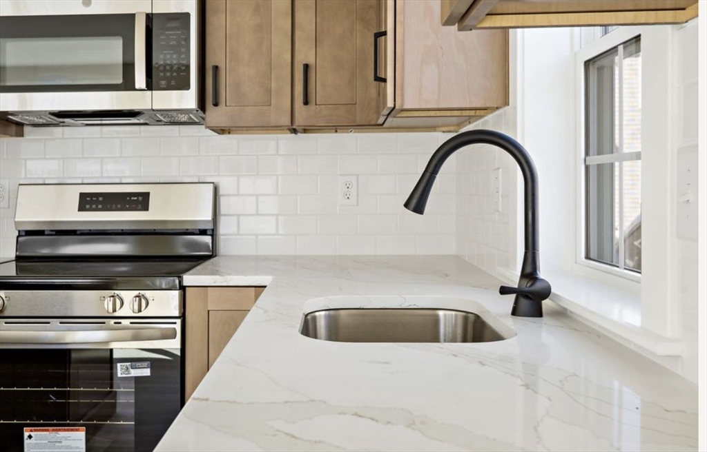 209 Main Street, Unit 1 Dennis, MA 02670 - Photo 12 of 28 a kitchen with a sink and a stove top oven