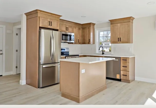 a kitchen with granite countertop a refrigerator and a sink