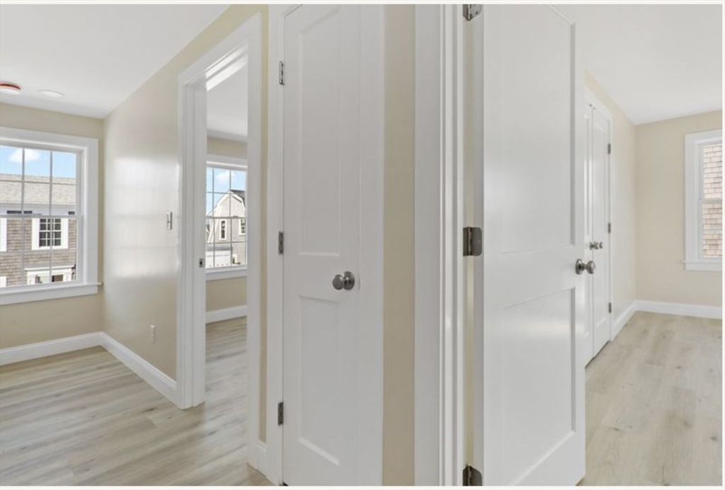 209 Main Street, Unit 1 Dennis, MA 02670 - Photo 22 of 28 a view of a hallway with wooden floor and closet area