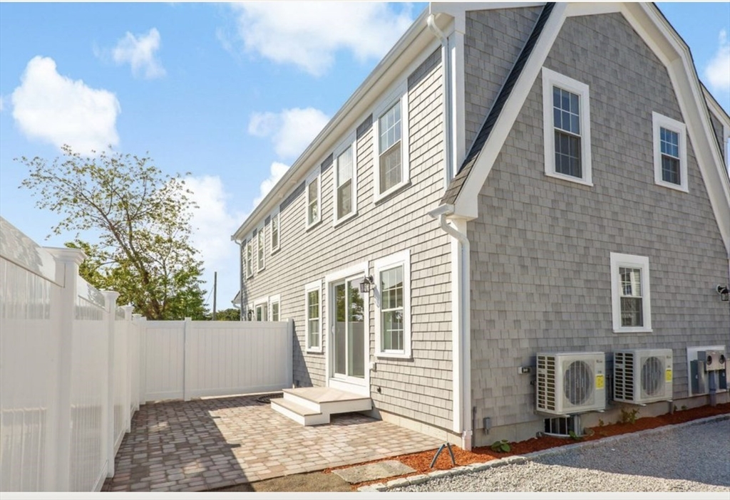 209 Main Street, Unit 1 Dennis, MA 02670 - Photo 7 of 28 a view of a brick house with many windows