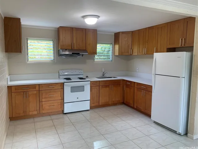 a kitchen with a refrigerator sink and cabinets