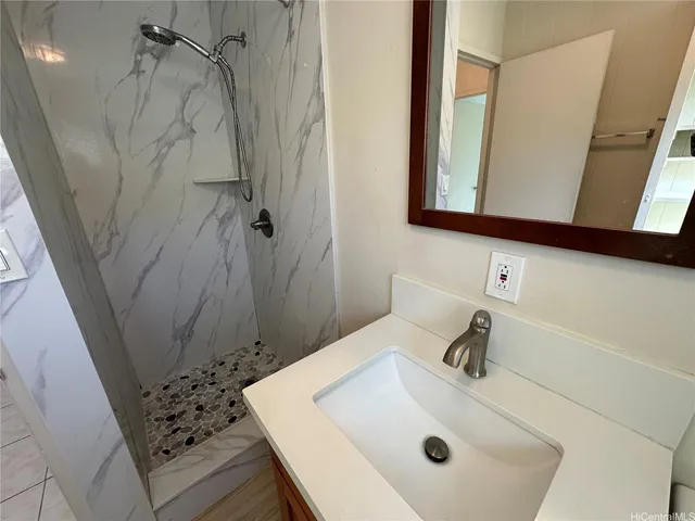 a bathroom with a sink a mirror and shower