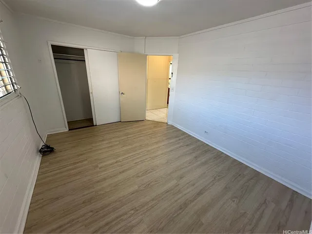 an empty room with wooden floor and closet