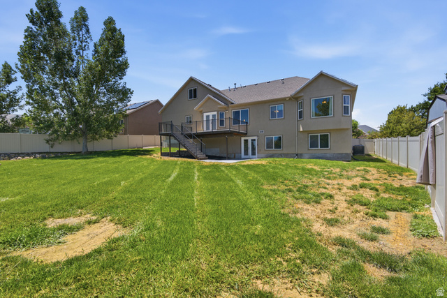 1252 Skyline Road Saratoga Springs, UT 84045 - Photo 47 of 51 Expansive backyard with a two-story residence featuring a second-level balcony, ground-level patio, multiple windows, and a privacy fence