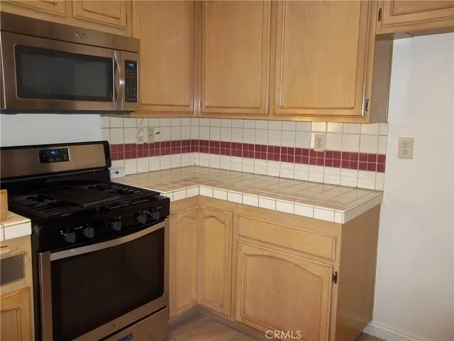 a kitchen with microwave cabinets and stove top oven