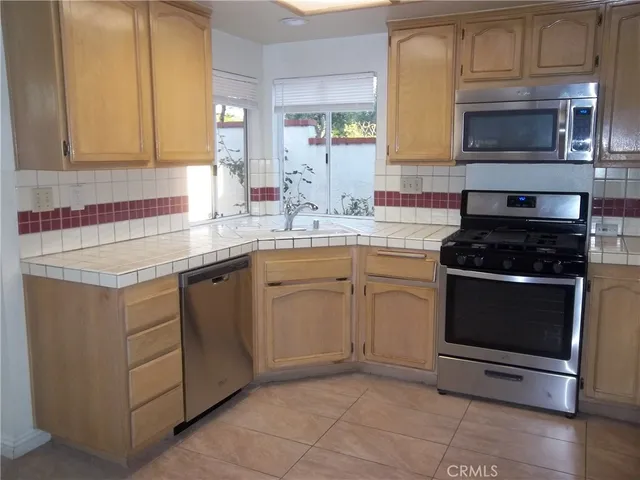 a kitchen with cabinets stainless steel appliances and a sink