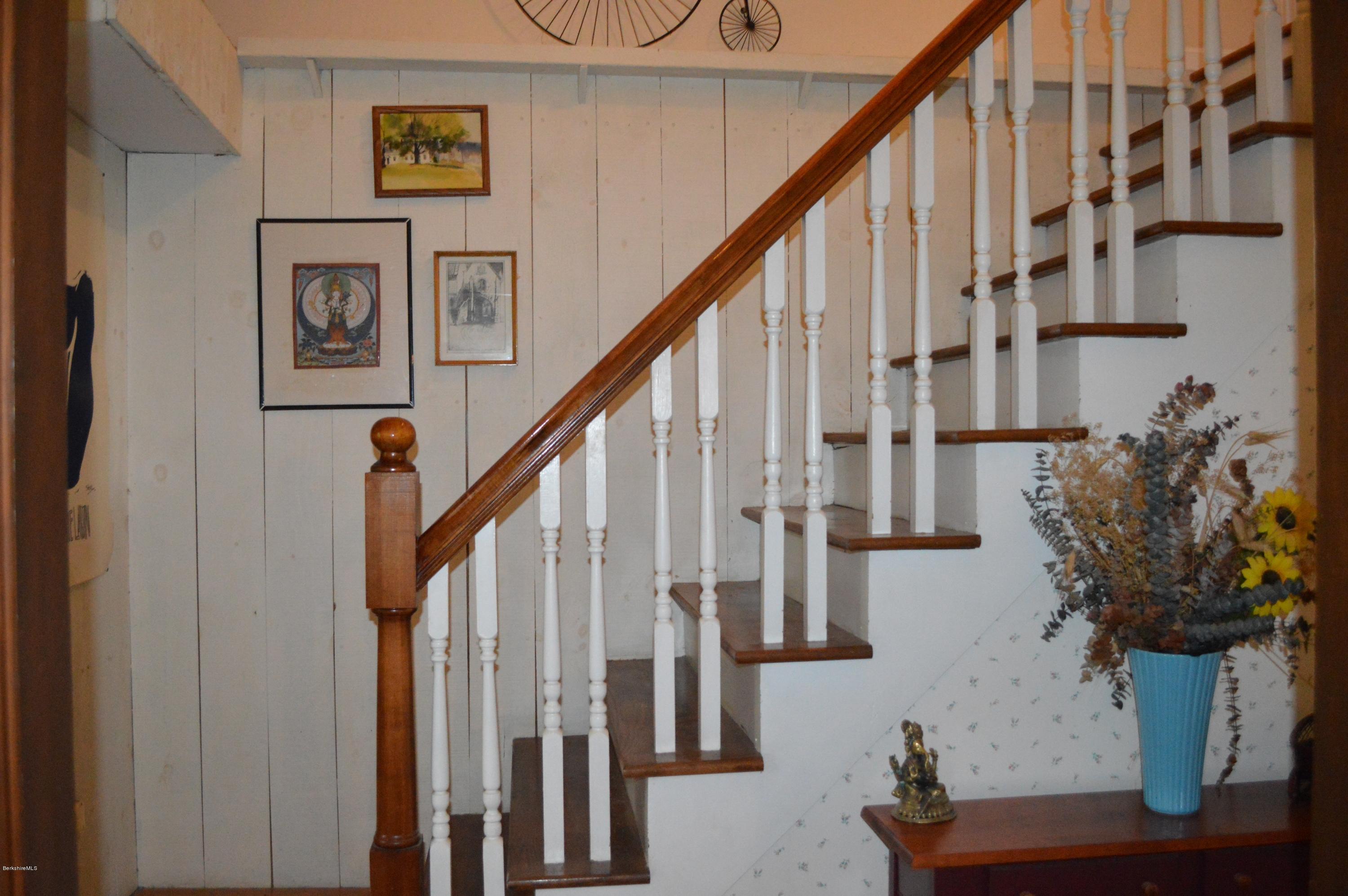 67 Main Road Tyringham, MA 01238 - Photo 17 of 20 a view of staircase with wooden floor and paintings on the wall