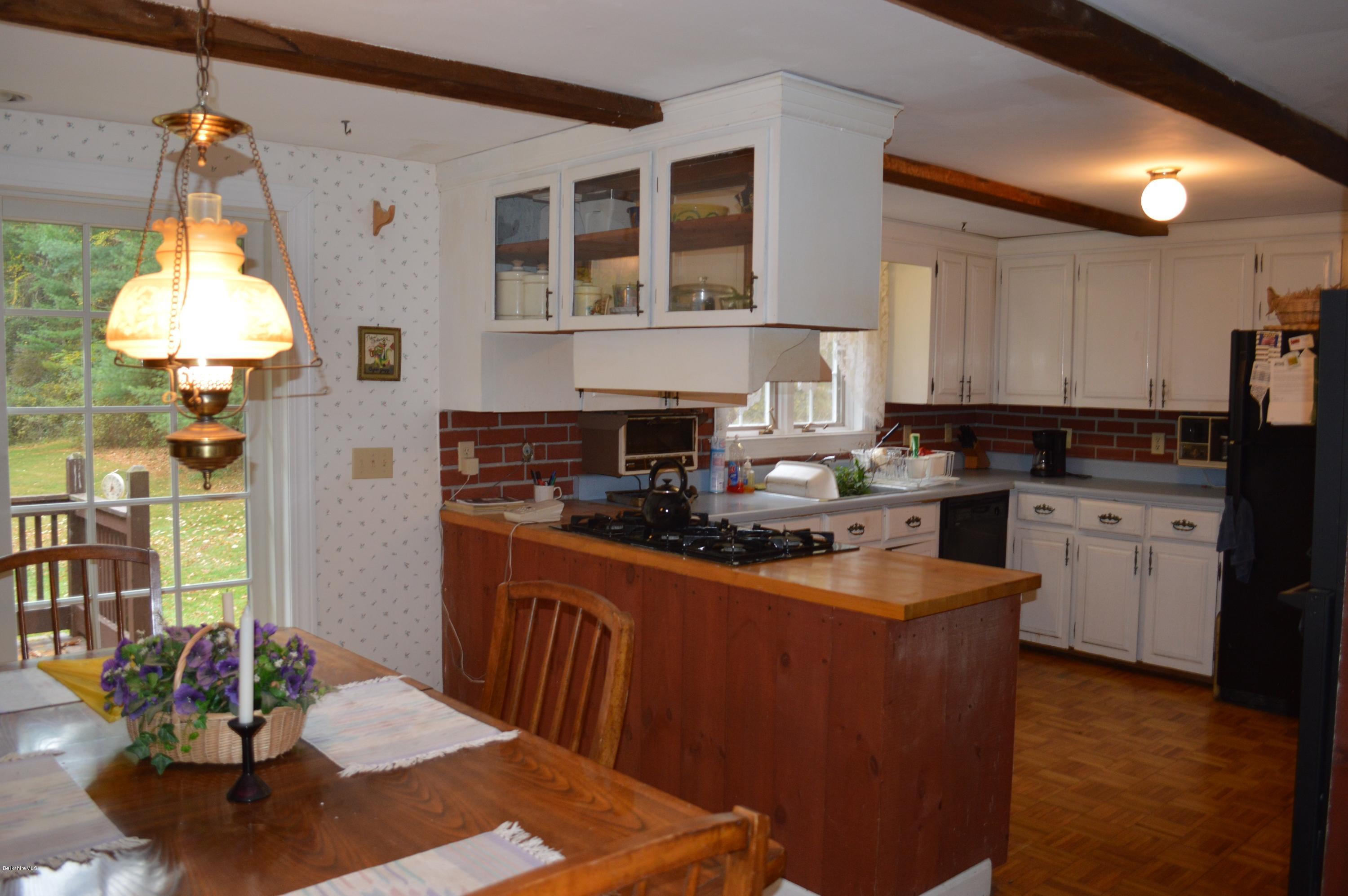 67 Main Road Tyringham, MA 01238 - Photo 6 of 20 a kitchen with stainless steel appliances granite countertop a refrigerator a sink dishwasher a stove and a dining table with wooden floor