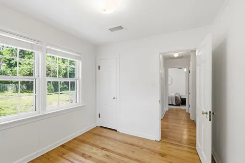 a view of a room with wooden floor and window