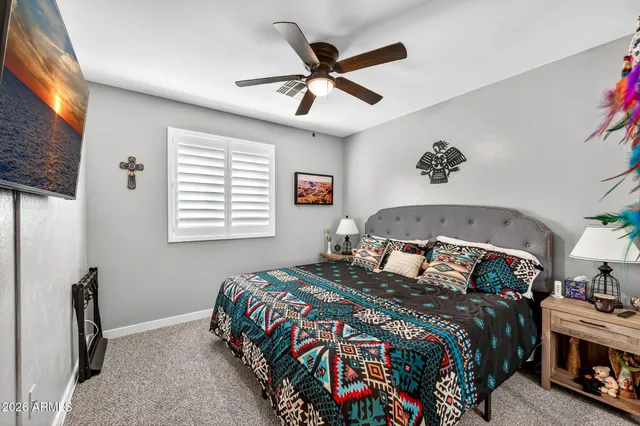 a view of a patio with couches table and chairs under an umbrella with potted plants