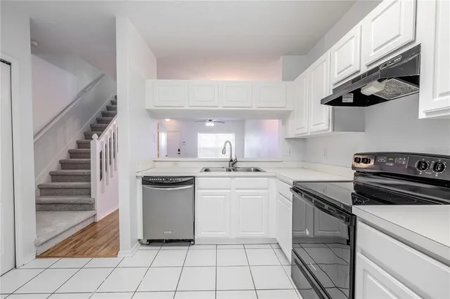 a kitchen with a stove sink and cabinets