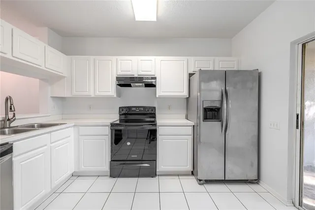 a kitchen with a refrigerator sink and cabinets