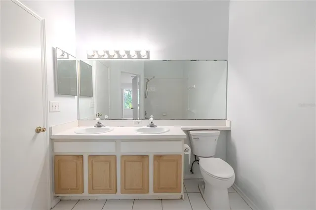 a bathroom with a granite countertop sink a toilet and a mirror