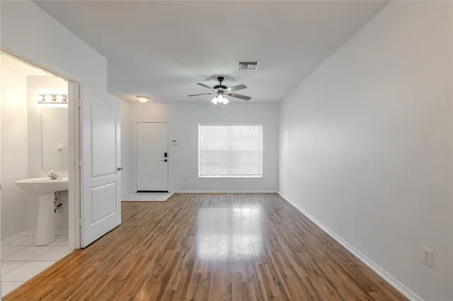 wooden floor in an empty room with a window