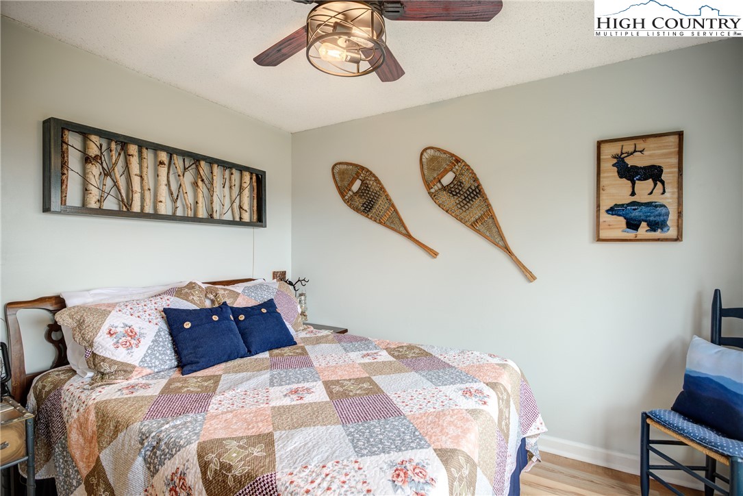 367 Skyleaf Drive, Unit D8 Banner Elk, NC 28604 - Photo 14 of 43 a bedroom with a bed and wooden floor