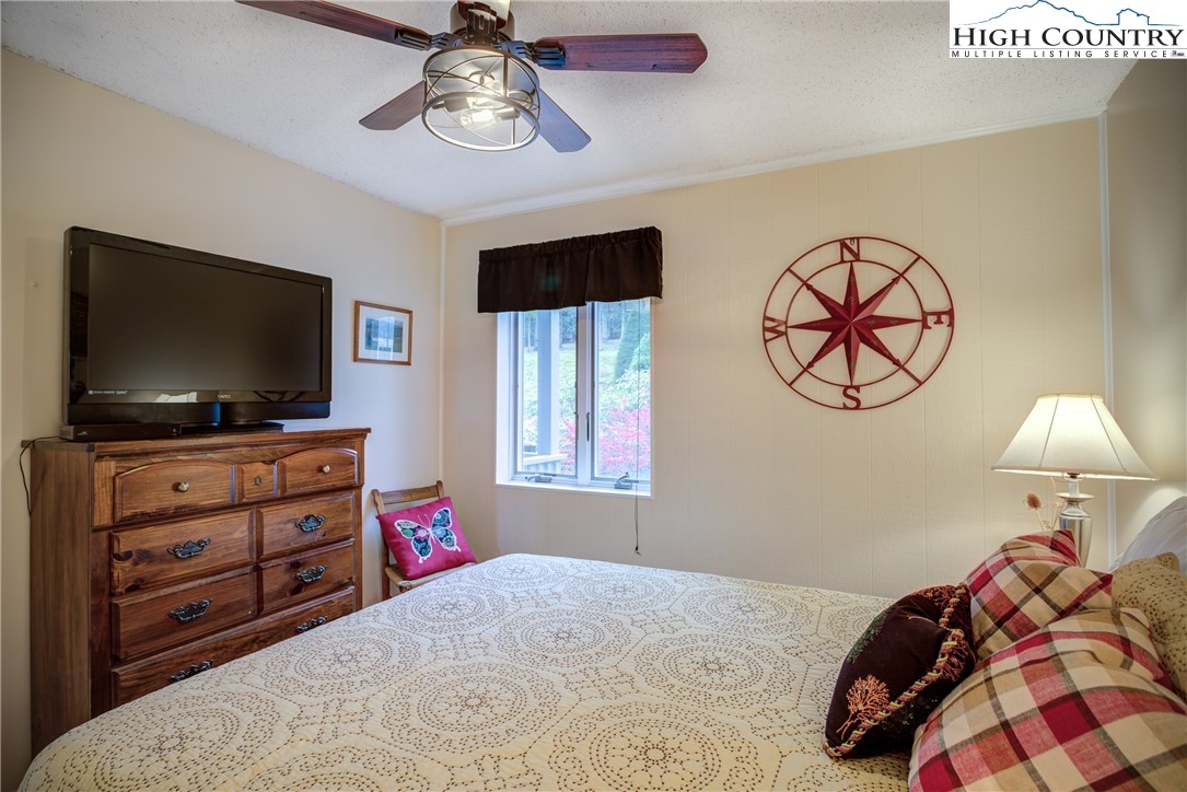 367 Skyleaf Drive, Unit D8 Banner Elk, NC 28604 - Photo 23 of 43 a bedroom with a bed and a flat tv screen on dresser