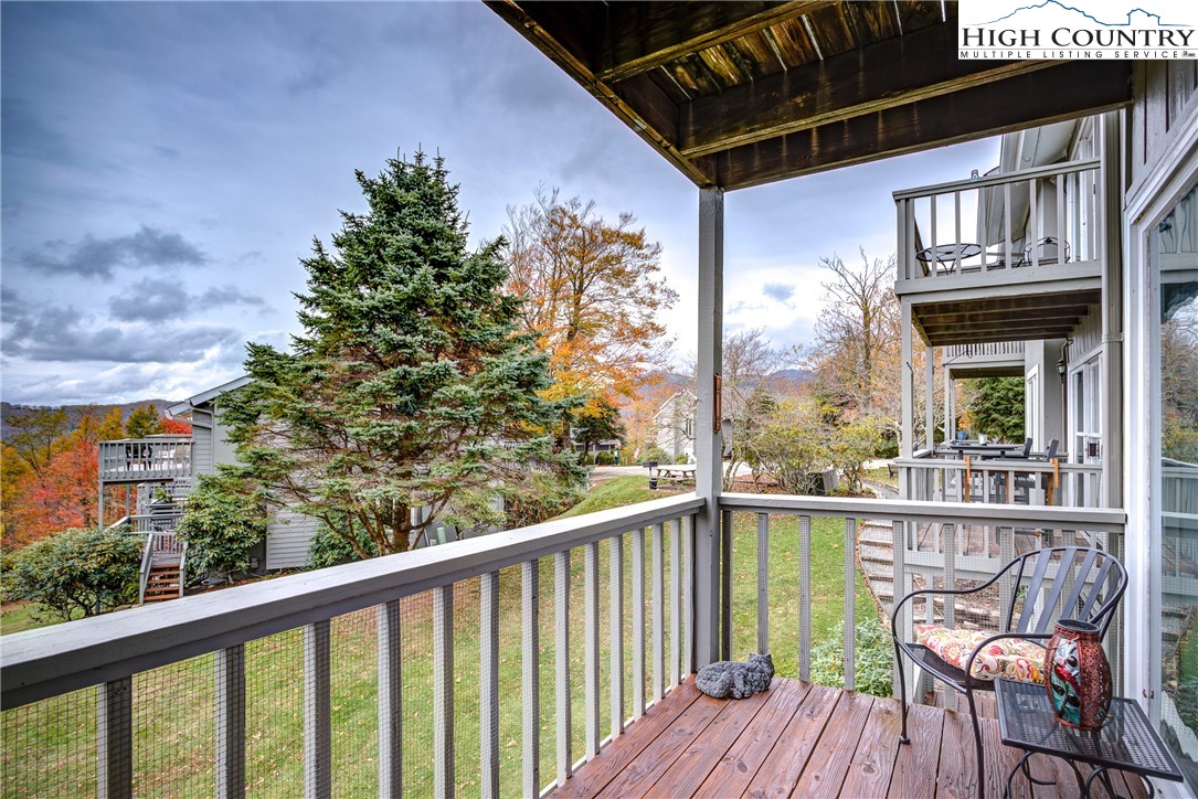 367 Skyleaf Drive, Unit D8 Banner Elk, NC 28604 - Photo 30 of 43 a view of a balcony with chairs and wooden floor